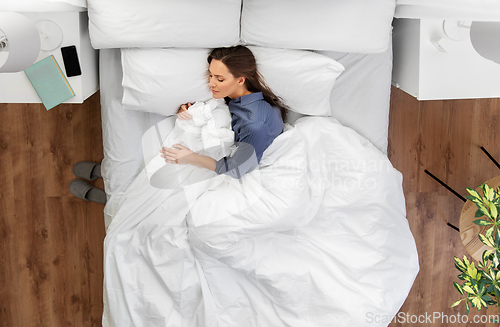 Image of young woman sleeping in bed at home