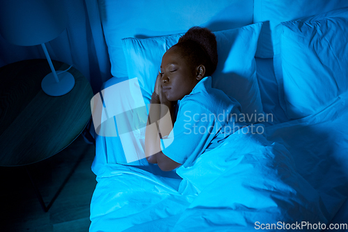 Image of african woman sleeping in bed at home at night