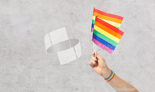 Image of hand with gay pride rainbow flags and wristband