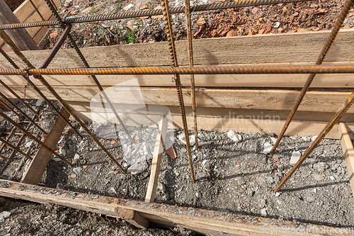 Image of Reinforcement covered with earth during the collapse of the formwork during the installation of strip foundation reinforcement