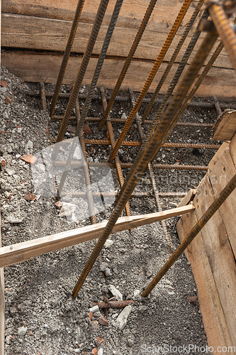 Image of Reinforcement of the corner of the strip foundation, the trench is partially covered with earth
