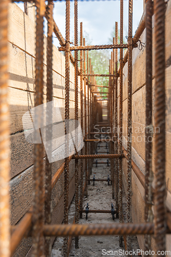 Image of Close-up of tied reinforcement and mounted strip foundation formwork, view inside the trench