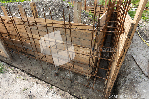 Image of Tied rebar and mounted formwork close-up before pouring the strip foundation when building a house