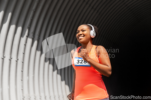 Image of happy african american woman running marathon