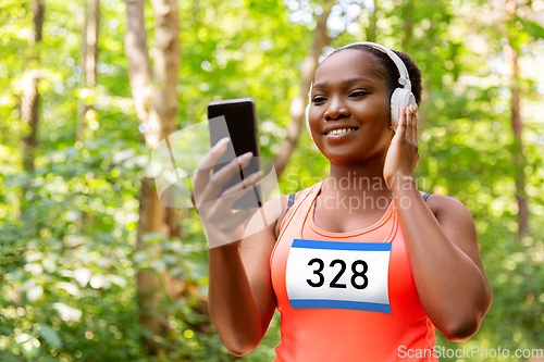 Image of female marathon runner with headphones and phone