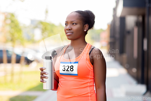 Image of female marathon runner drinking water from bottle