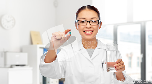 Image of asian doctor with medicine and glass of water