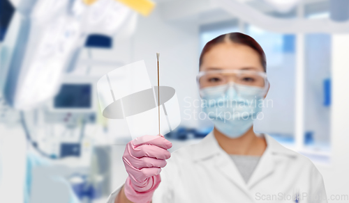 Image of asian female doctor in mask with test cotton swab