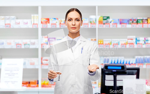 Image of doctor with medicine and water at pharmacy