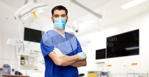 Image of male doctor in blue uniform, mask and gloves