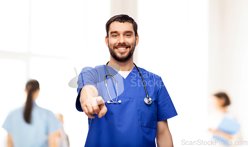 Image of smiling doctor or male nurse pointing to camera