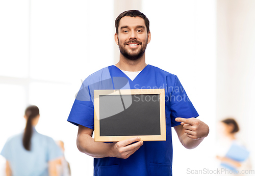 Image of happy smiling male doctor or nurse with chalkboard