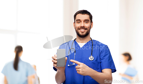 Image of smiling doctor or male nurse with smartphone