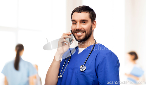 Image of smiling doctor or male nurse calling on smartphone