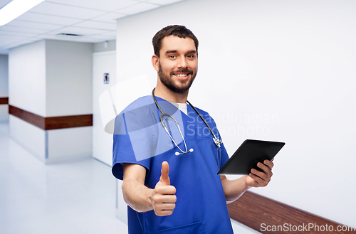 Image of male doctor with tablet pc showing thumbs up