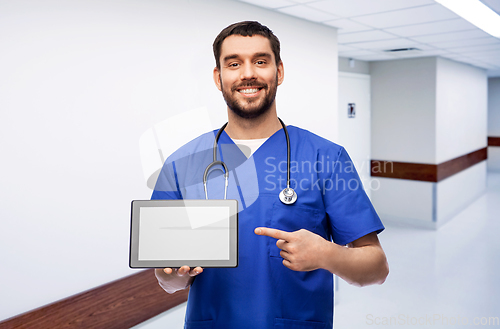 Image of happy doctor or male nurse showing tablet computer