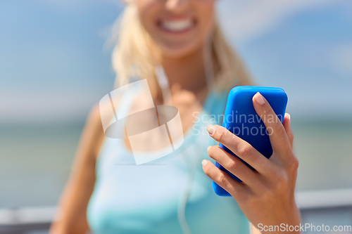 Image of sporty young woman with smartphone and earphones