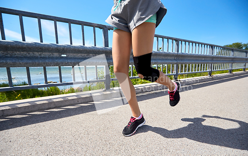 Image of feet of young woman running outdoors