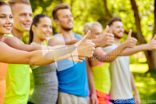 Image of group of happy sporty friends showing thumbs up