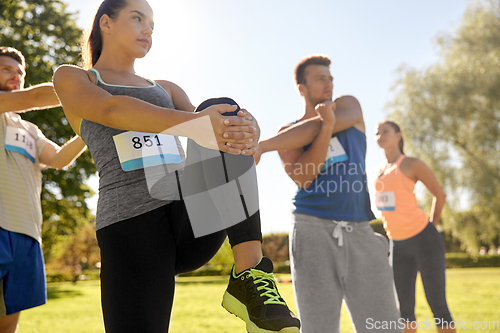 Image of happy people exercising with trainer at park