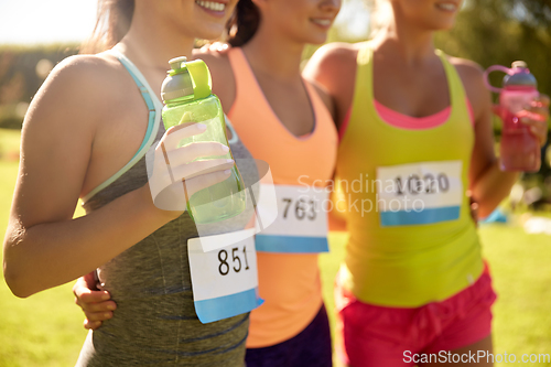 Image of happy young sporty women with racing badge numbers