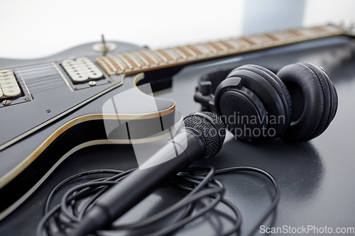 Image of close up of bass guitar, microphone and headphones