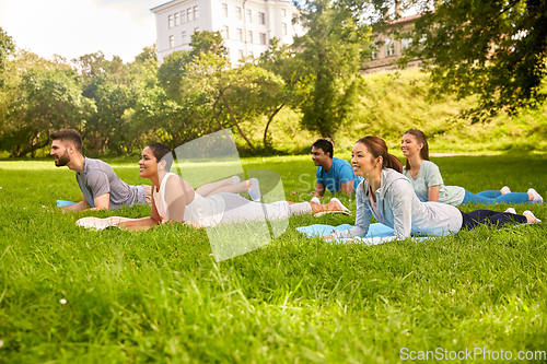 Image of group of people doing yoga at summer park