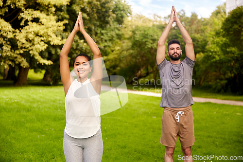 Image of happy people doing yoga at summer park