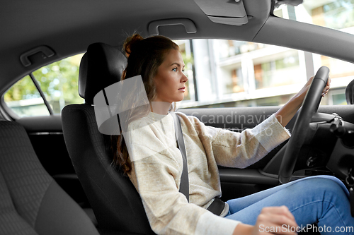 Image of woman or female driver driving car in city