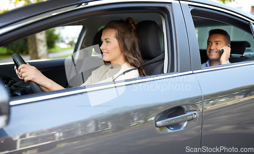 Image of female driver driving car with male passenger