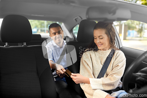 Image of female car driver takes credit card from passenger