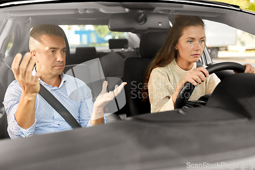 Image of car driving school instructor teaching woman