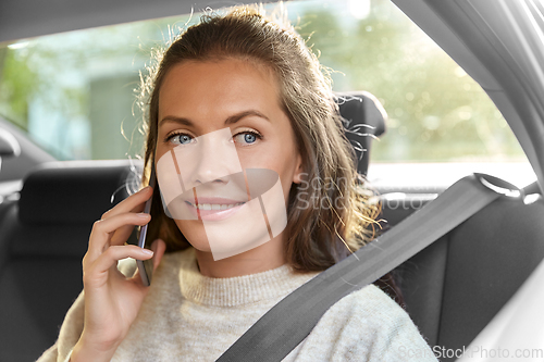 Image of happy smiling woman in car calling on smartphone