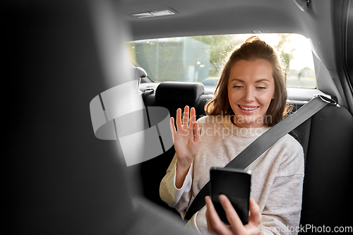 Image of happy woman in car having video call on smartphone