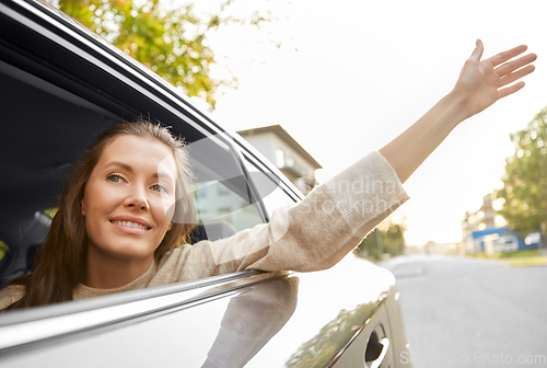 Image of happy smiling woman or female passenger in car