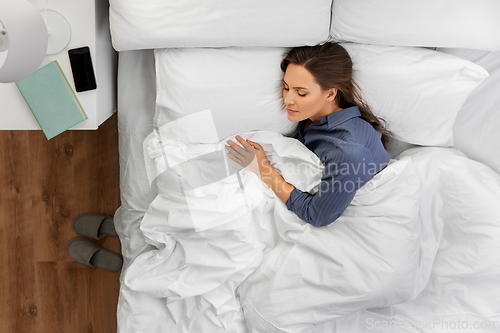 Image of young woman sleeping in bed at home