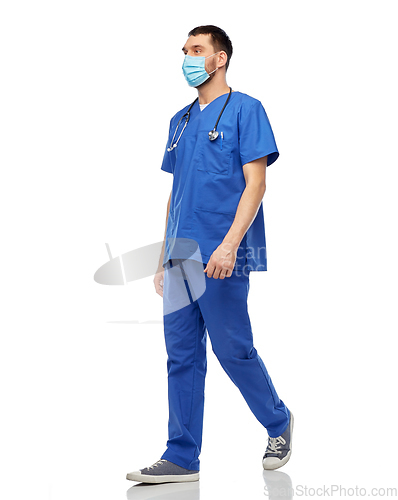 Image of male doctor in blue uniform and mask walking