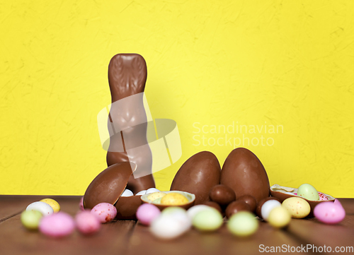 Image of chocolate eggs, easter bunny and candies on wood