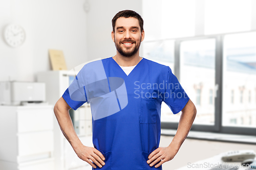 Image of happy smiling doctor or male nurse in blue uniform