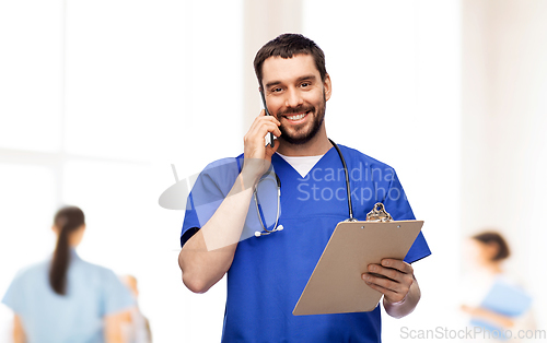 Image of smiling doctor or male nurse calling on smartphone