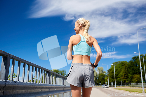 Image of sporty young woman running outdoors