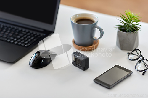 Image of action camera and other media on office table