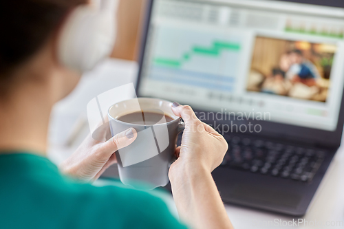 Image of woman with video editor program on laptop at home