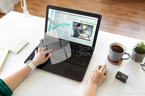 Image of woman with video editor program on laptop at home