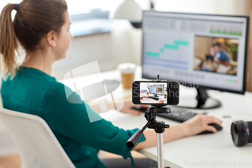 Image of smartphone recording woman working in video editor
