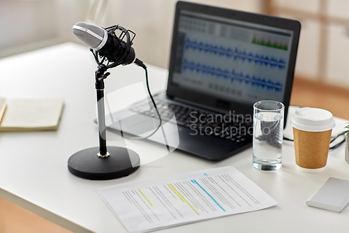 Image of microphone and sound editor on laptop at office