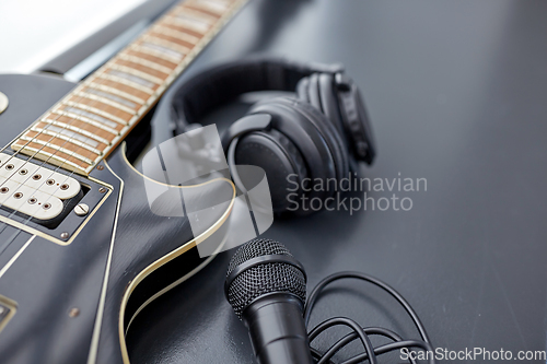 Image of close up of bass guitar, microphone and headphones