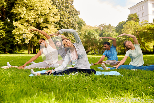 Image of group of people exercising at summer park