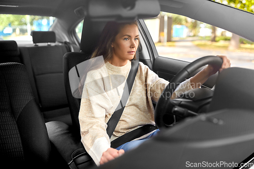 Image of woman or female driver driving car in city