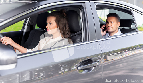 Image of female driver driving car with male passenger